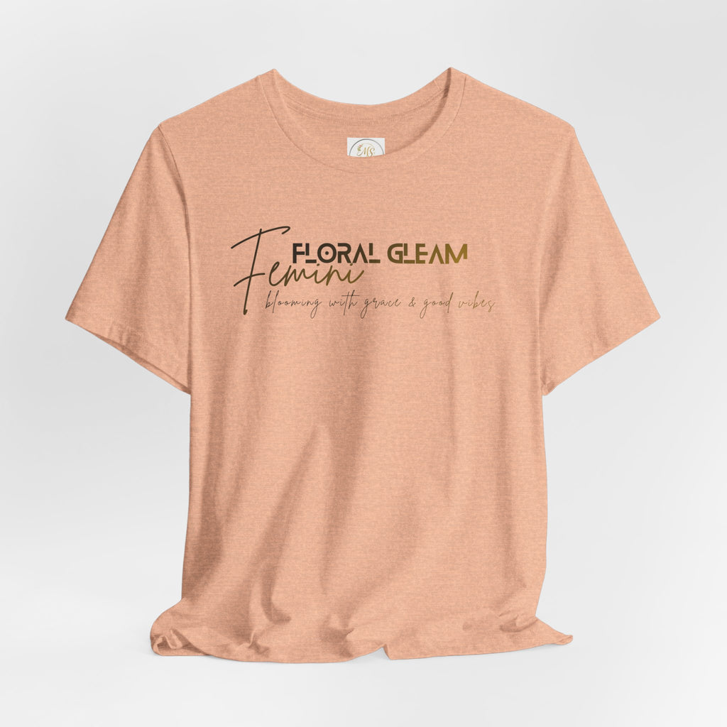 Peach-colored t-shirt with 'Floral Gleam Feminine' text on a light gray background