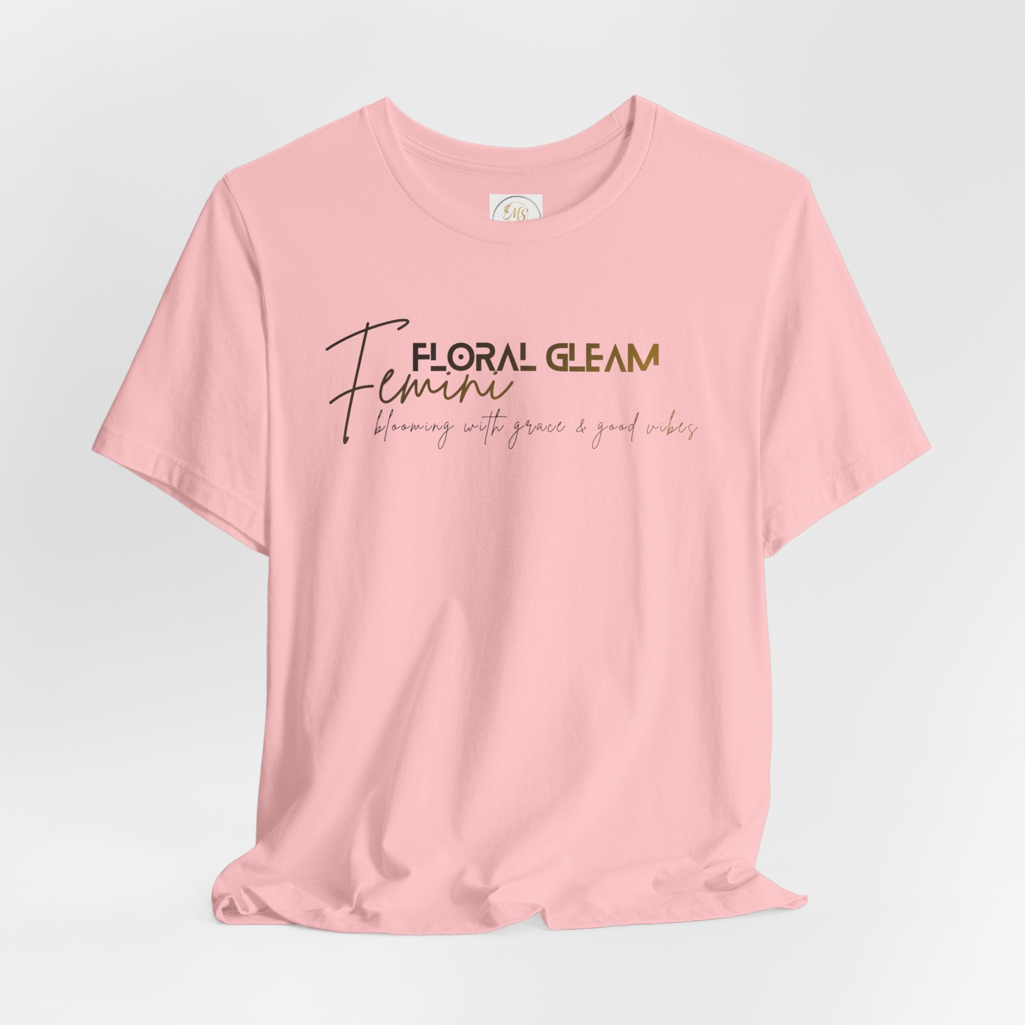 Pink t-shirt with 'Floral Gleam Feminine' text on a light gray background