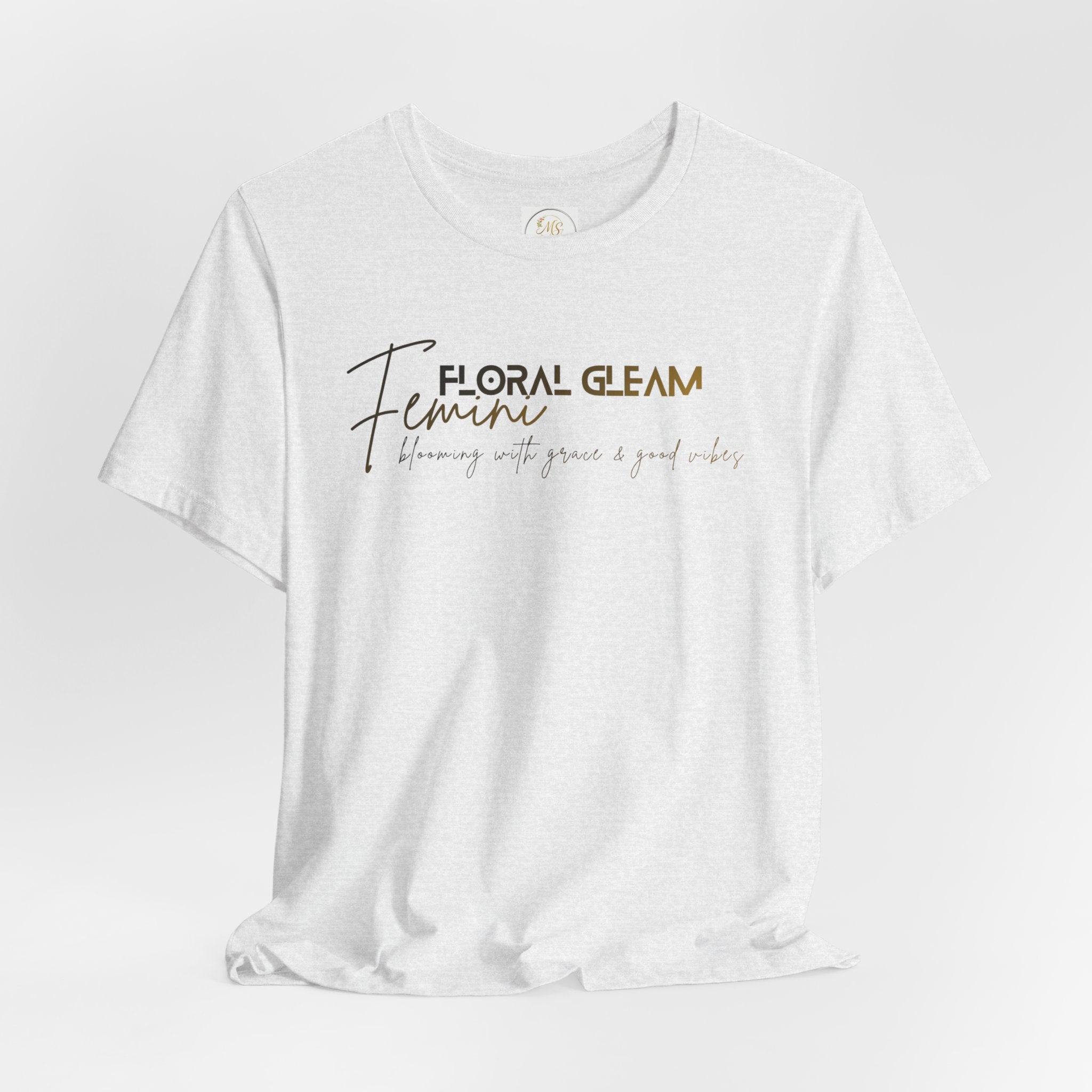White t-shirt with 'Floral Gleam Feminine' text on a light gray background